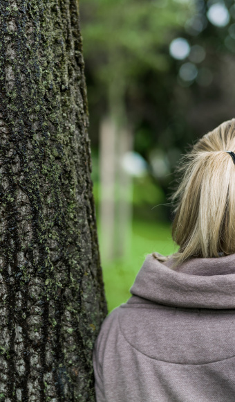 Frau an Baum angelehnt, Titelbild Studierende mit psychischen Erkrankungen